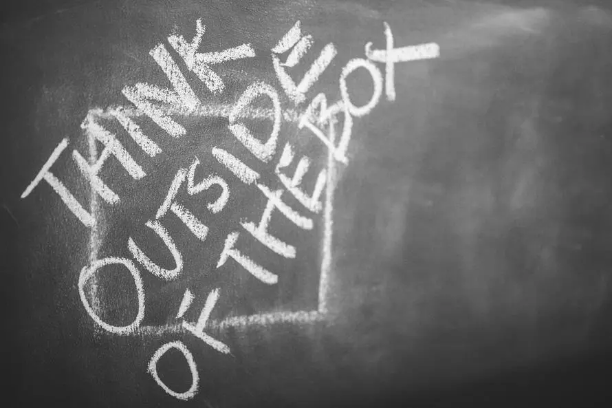 Das Bild zeigt eine Wandtafel mit dem Text Think outside the box. Es steht als Symbol für eine kreative Konzeption auf dem Weg zu Ihrer eigenen Website..